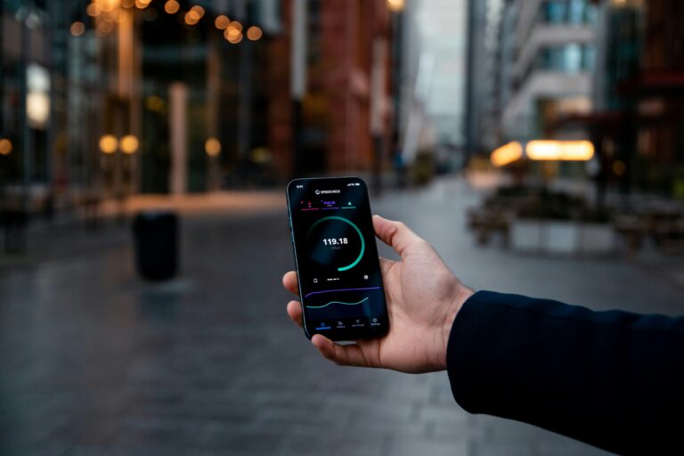 A hand holding a phone with a mobile network connectivity speed check